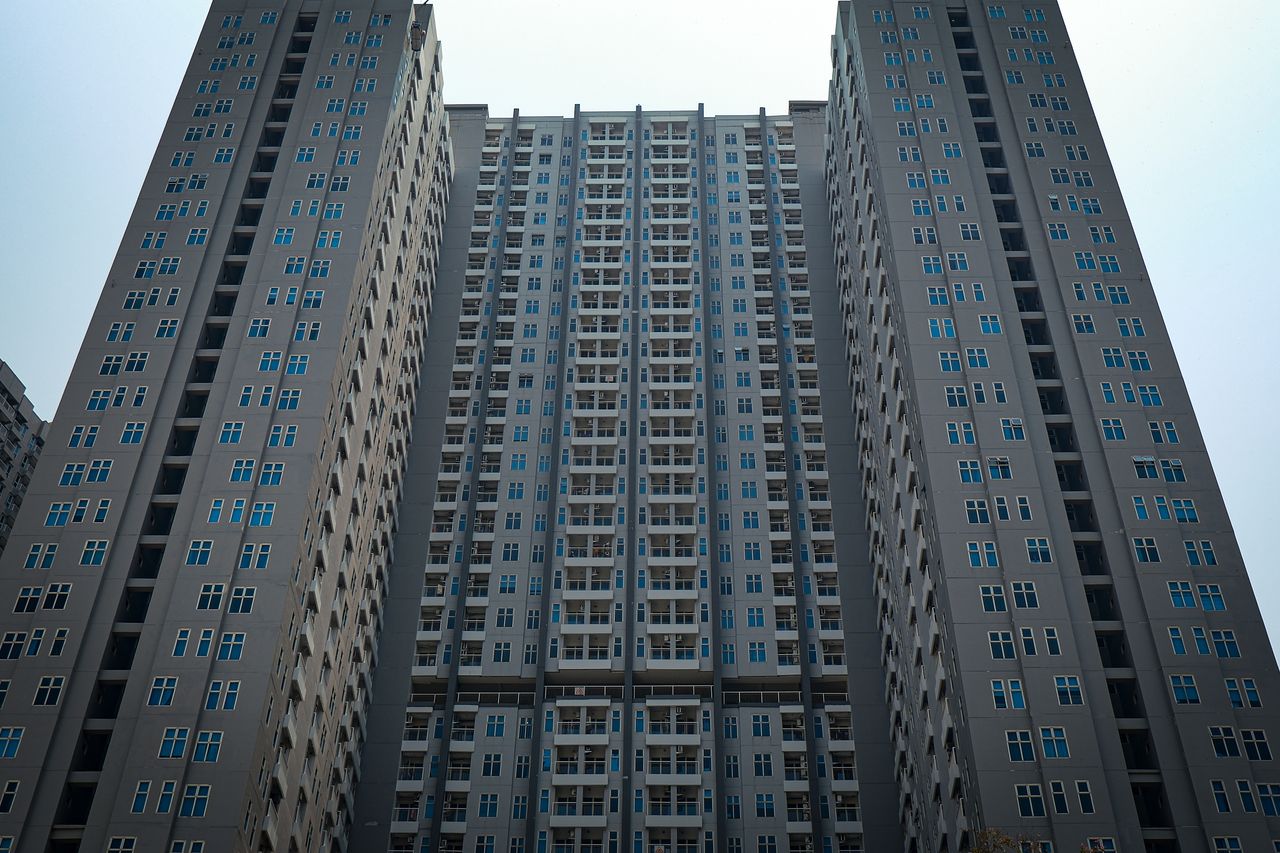A towering view of modern high-rise residential buildings under a clear sky.